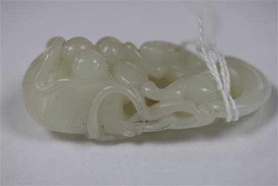 A Chinese white jade carving of a squirrel, grapes and lotus leaf, 18th/19th century, L. 6.4cm, wood stand